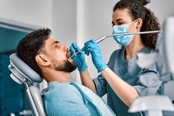Dentist performing teeth cleaning for a patient in Jacksonville, TX